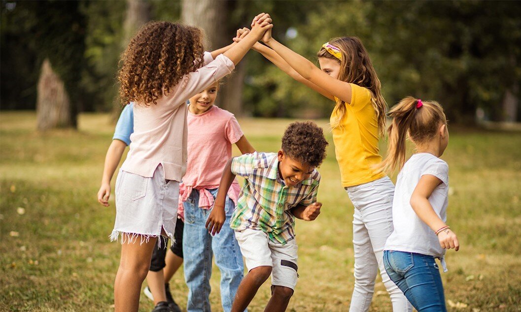 Grundschulkinder spielen fröhlich draußen  | © iStock/Liderina